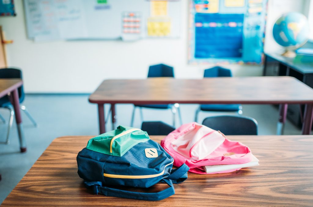 two backpacks on table in classroom